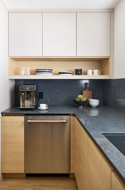Modern kitchen with wooden cabinets, stainless steel appliances, and a dark countertop.