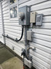 Electrical panel and meters mounted on a building exterior