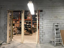 Basement interior with exposed brick walls, ladder, and storage shelves