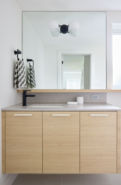 Bathroom vanity with wooden cabinets, mirror, and sink.