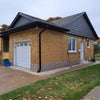 Brick house with a white garage door and black roof
