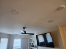 Ceiling with ceiling fans and speakers, wall-mounted TV, and shelves.