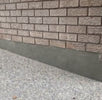 Close-up of brick wall and adjacent concrete surface detail