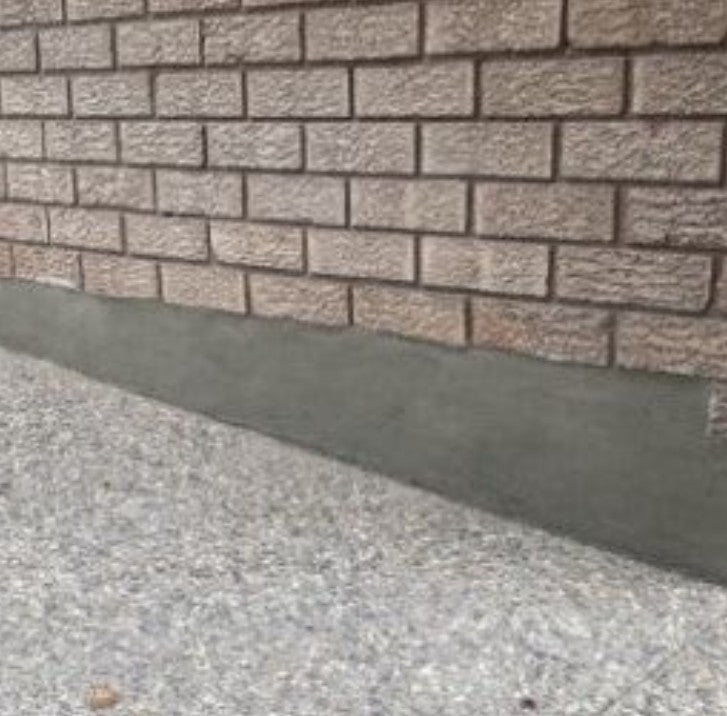 Close-up of brick wall and adjacent concrete surface detail