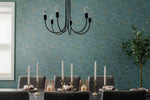 Dining room with a chandelier, candles, and a plant against a patterned wall.