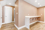 Empty residential room with beige walls, hardwood flooring, and white baseboards