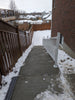 Concrete staircase leading up to a house with snow on the ground