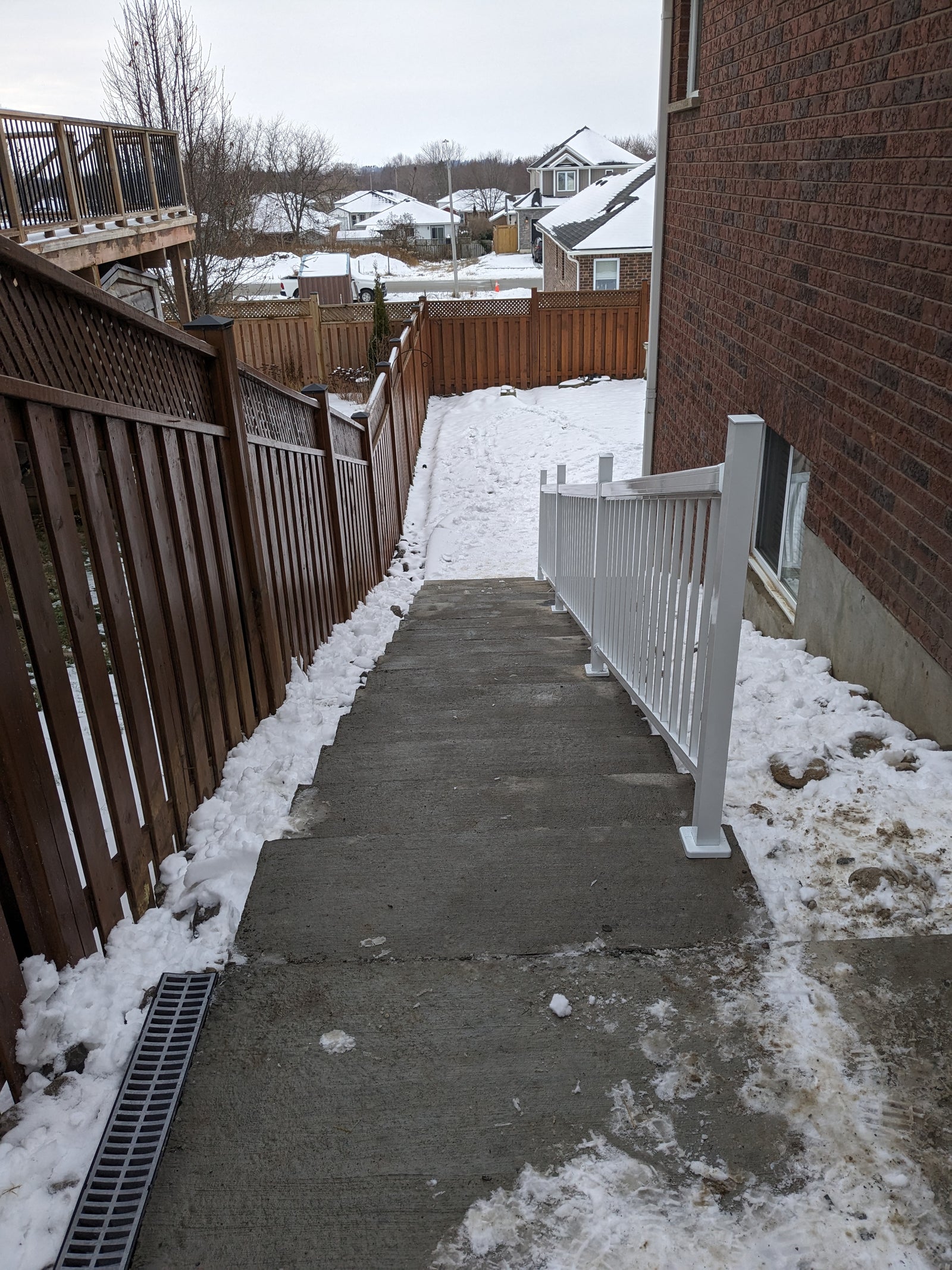 Concrete staircase leading up to a house with snow on the ground