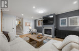 Living room with gray walls, white sofa, and a fireplace.