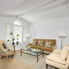 Living room with brown sofa, beige armchair, and glass coffee table.