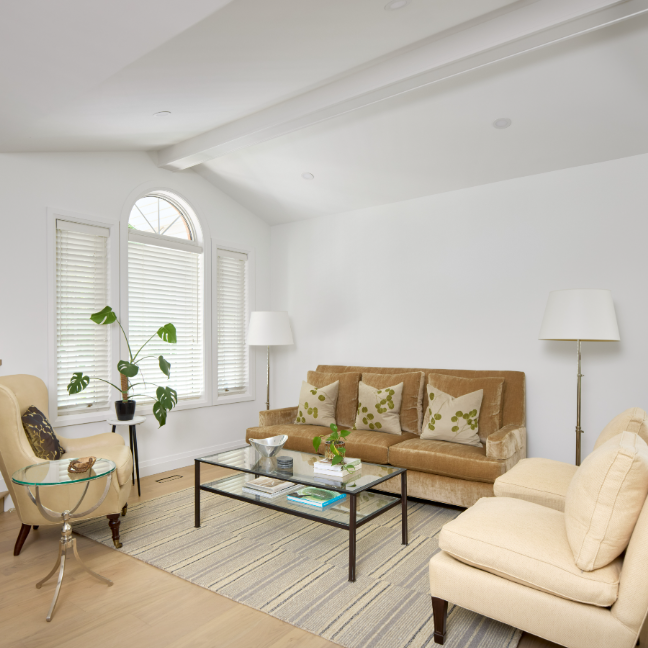Living room with brown sofa, beige armchair, and glass coffee table.
