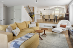 Living room with beige sectional sofa, white armchair, and wooden coffee table.