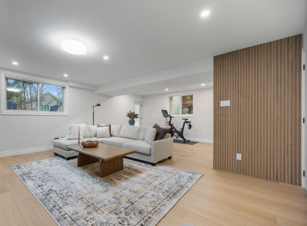 Modern living room with sectional sofa, coffee table, and exercise bike.