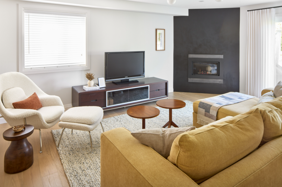 Modern living room with yellow sofa, white armchair, and television.