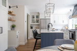 Modern kitchen with blue island, white cabinets, and stainless steel appliances.