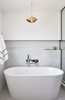 Modern bathroom with a freestanding bathtub, sink, and decorative elements.
