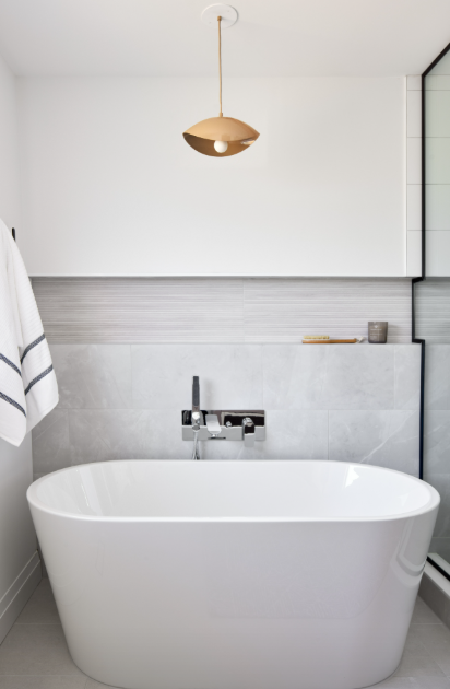 Modern bathroom with a freestanding bathtub, sink, and decorative elements.