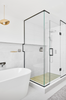 Modern bathroom with freestanding bathtub and glass shower enclosure.