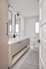 Modern bathroom with a vanity, mirror, and toilet.