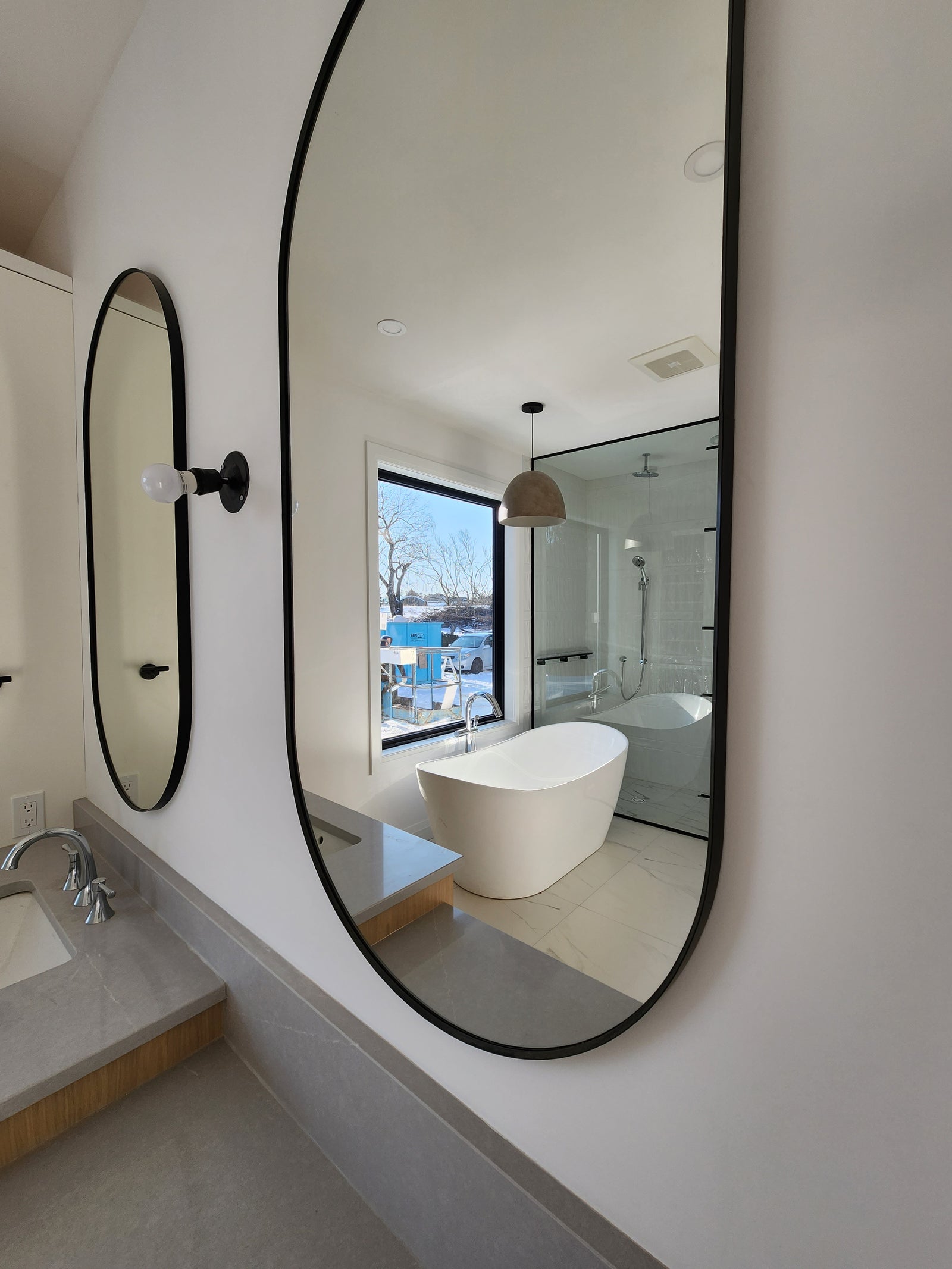 Modern interior design with curved glass panels and white furniture.
