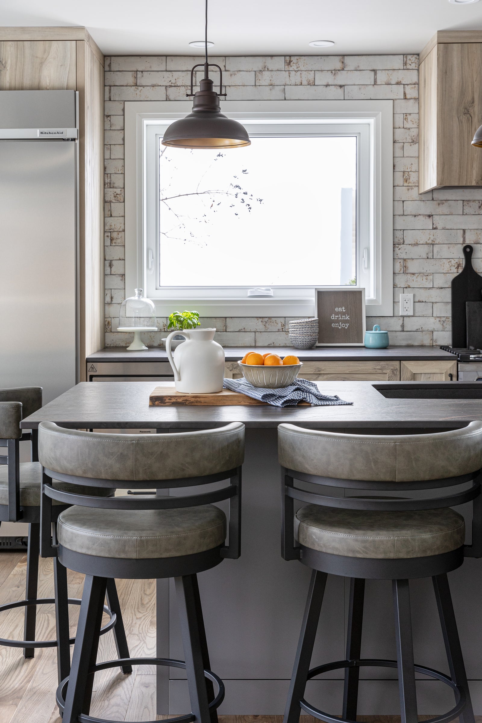 Modern kitchen with island, stools, and decorative elements.