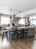 Modern kitchen with island and stools in a well-lit room