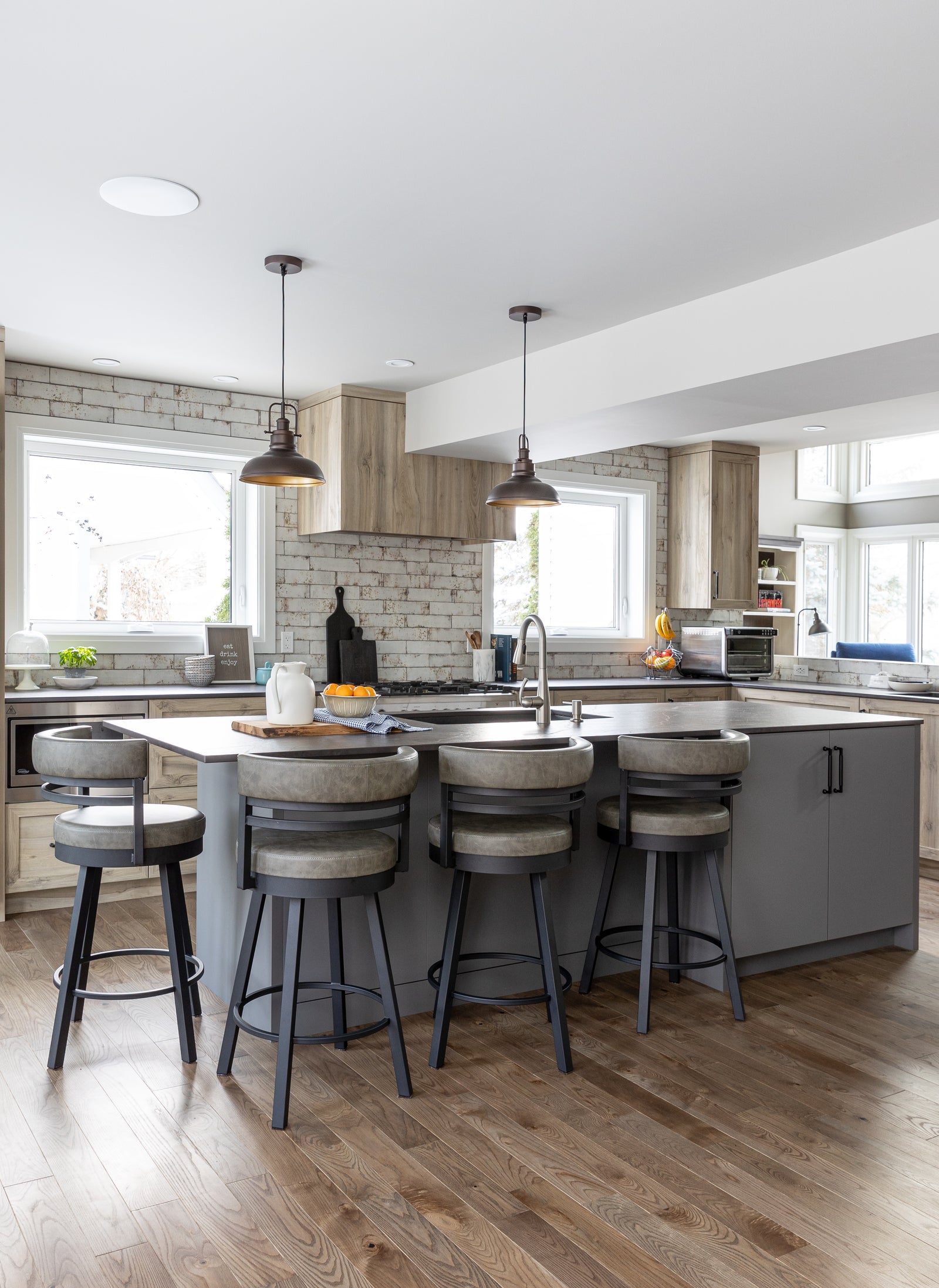 Modern kitchen with island and stools in a well-lit room
