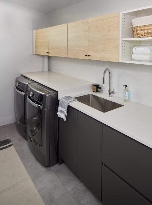 Modern laundry room with washing machine, dryer, and kitchen-like setup.