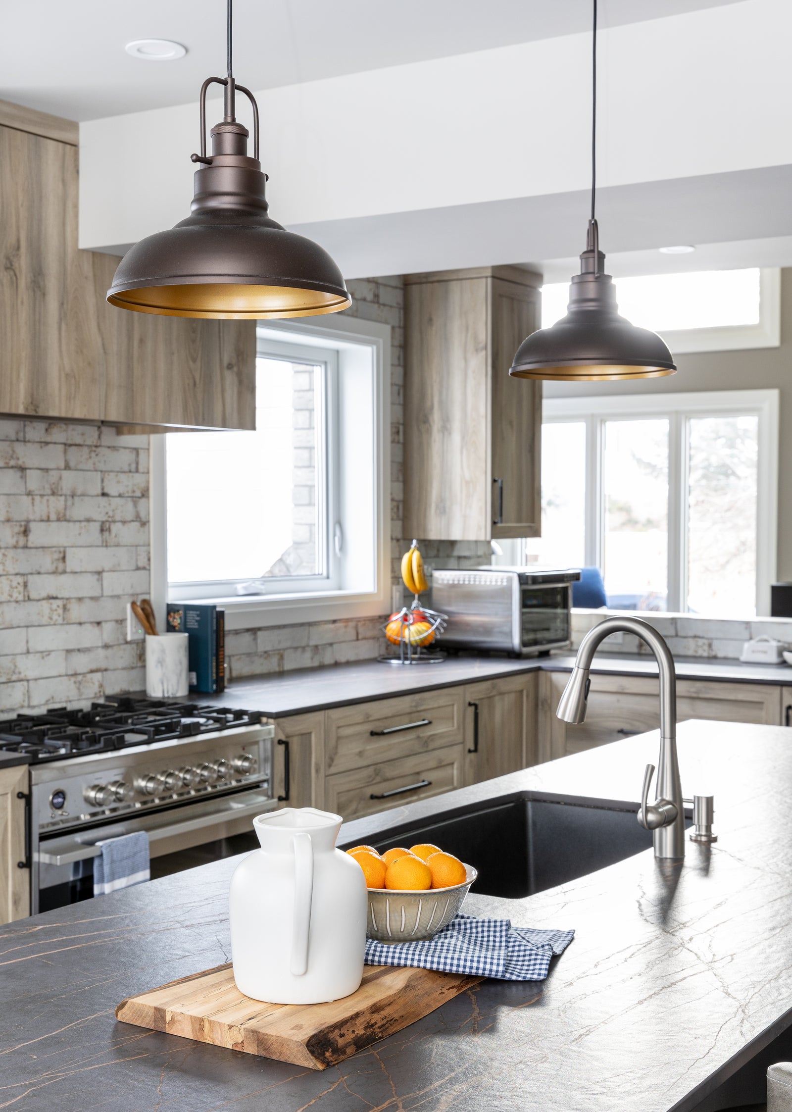 Modern kitchen with stainless steel appliances, wooden cabinets, and pendant lights.