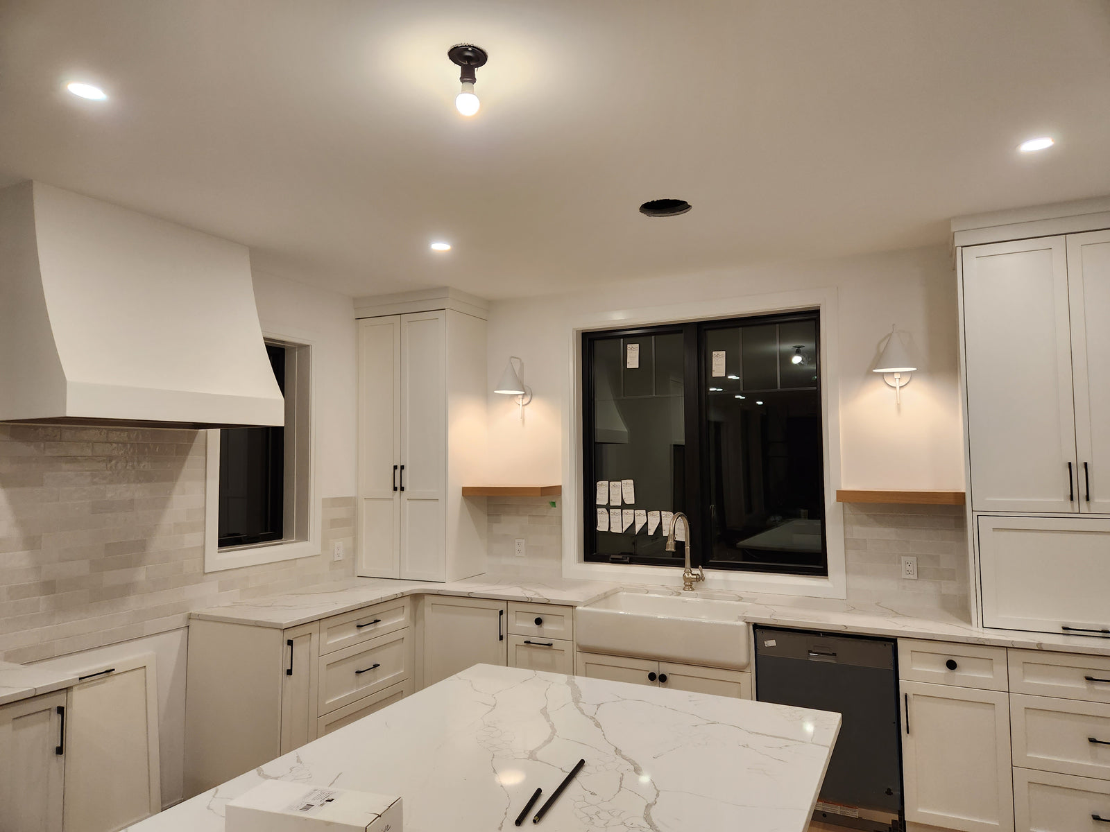 Modern kitchen with white cabinets, marble countertop, and stainless steel appliances.