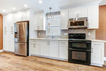 Modern kitchen with stainless steel appliances and white cabinets.