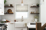 Modern kitchen with white subway tile backsplash, wooden shelves, and stainless steel appliances.