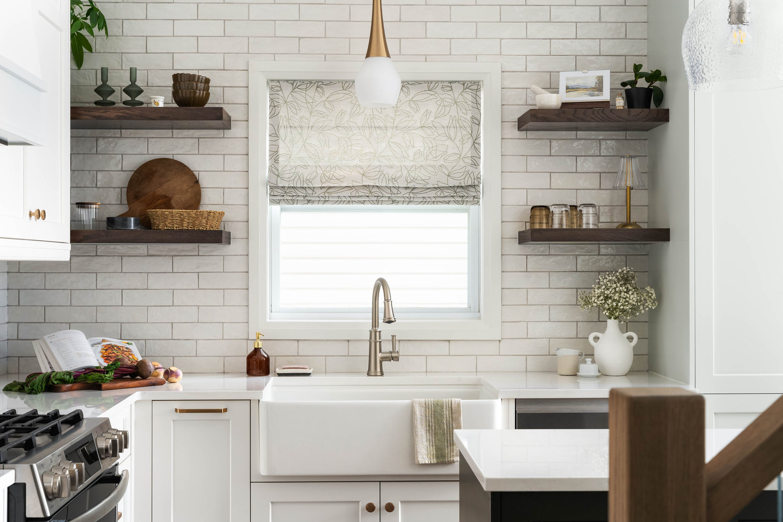 Modern kitchen with white subway tile backsplash, wooden shelves, and stainless steel appliances.