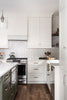 Modern kitchen with white cabinets, stainless steel appliances, and a subway tile backsplash.