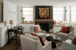 Modern living room with white sofa, colorful accent pillows, and built-in fireplace feature wall