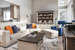 Modern living room with a sectional sofa, coffee table, and decorative pillows.