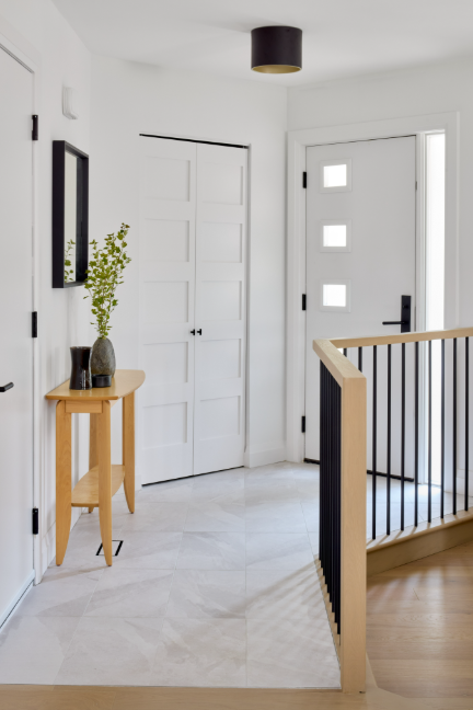 Modern interior with white walls, wooden floor, and a small table with decor items.