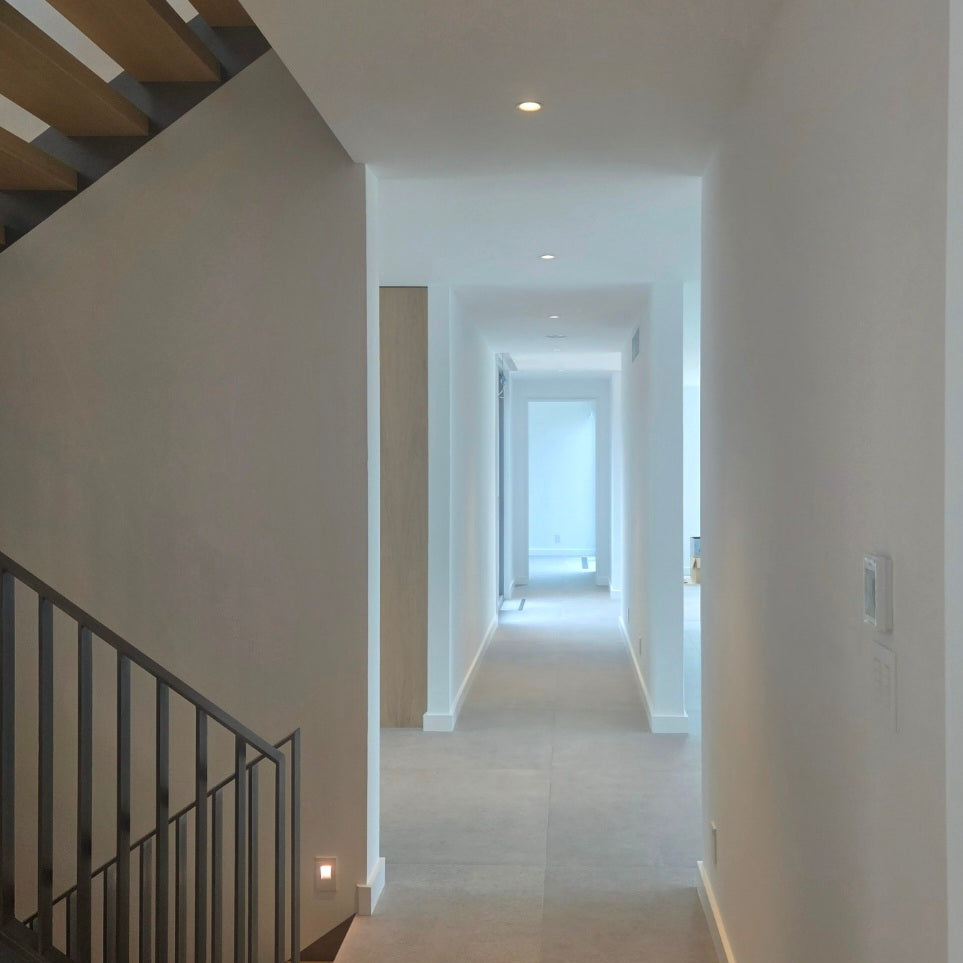 Modern staircase with a hallway leading to a bright room