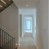 Modern staircase with a hallway leading to a bright room