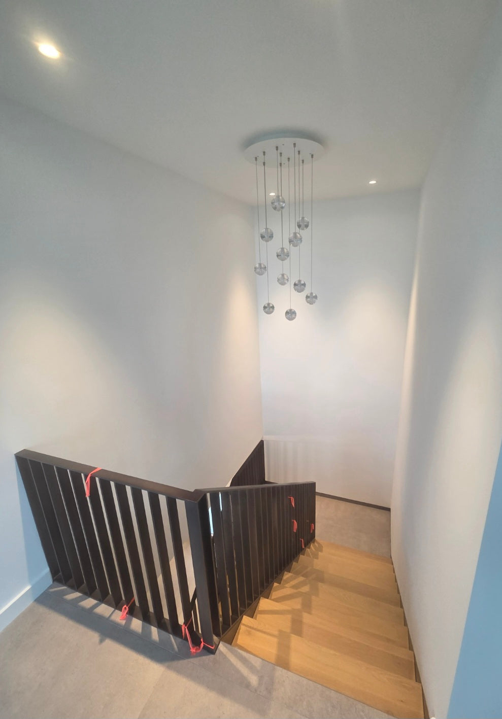 Modern staircase with a black railing in a well-lit room.