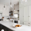 Modern kitchen design with white cabinets, center island, and decorative pendant lighting