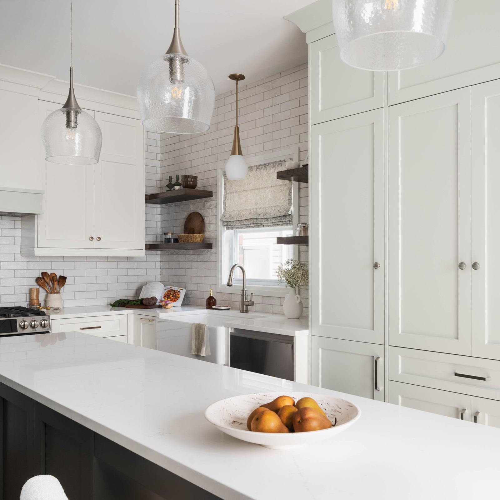 Modern kitchen design with white cabinets, center island, and decorative pendant lighting