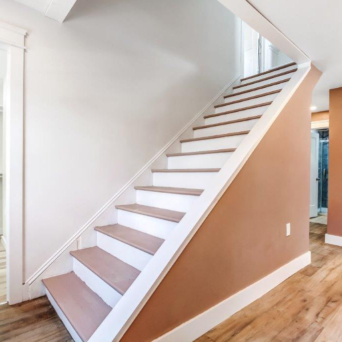 Staircase with wooden steps and white risers in a home interior.