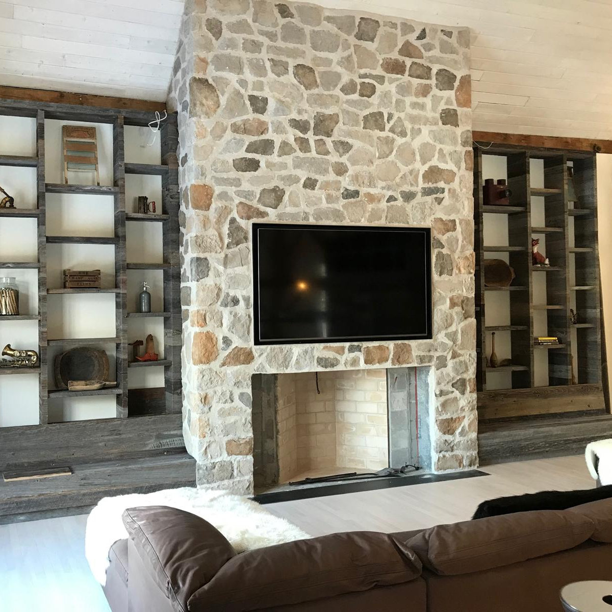 Modern living room with natural stone fireplace and built-in shelving units