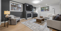 Living room with gray sofa, armchair, coffee table, and fireplace.