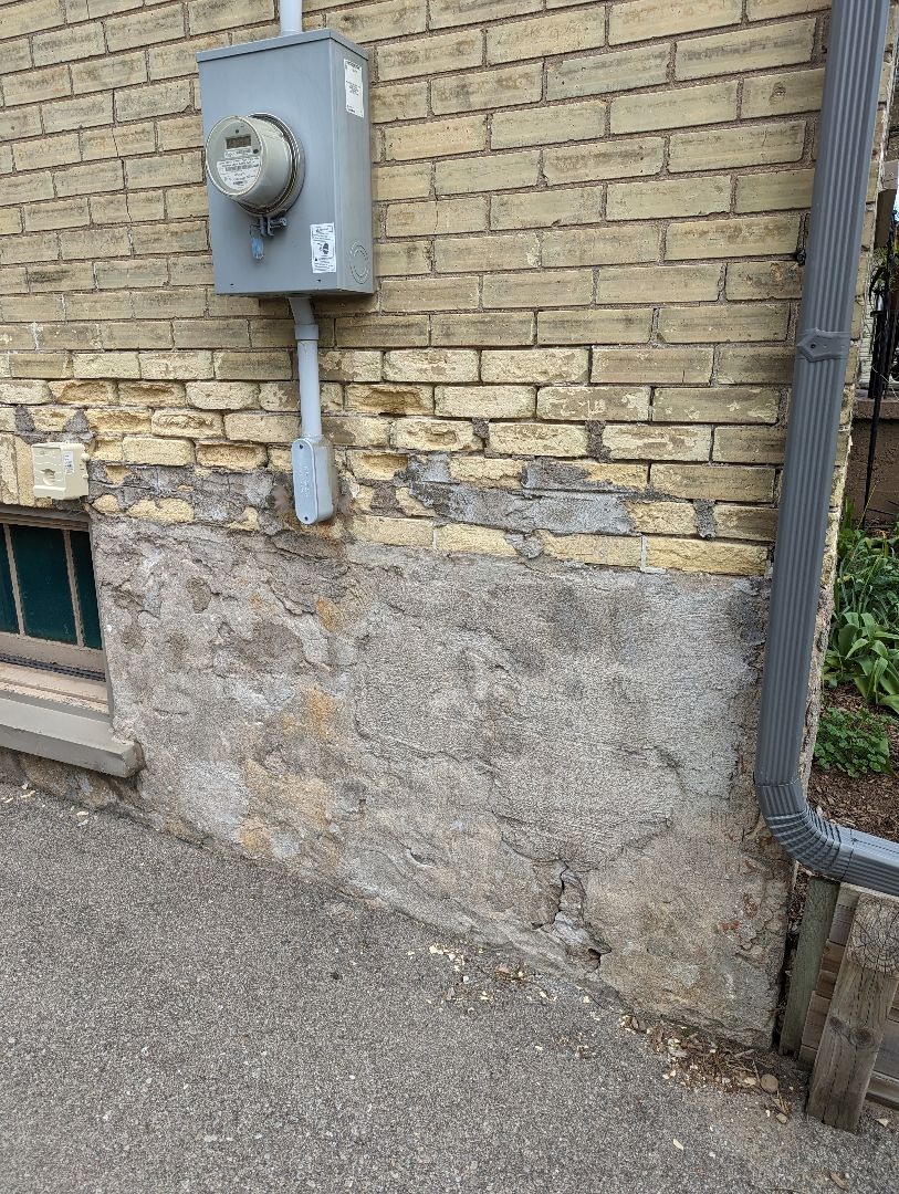 Utility meter on a brick wall with a concrete base