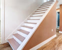 Interior staircase with wooden steps and white risers in residential home.