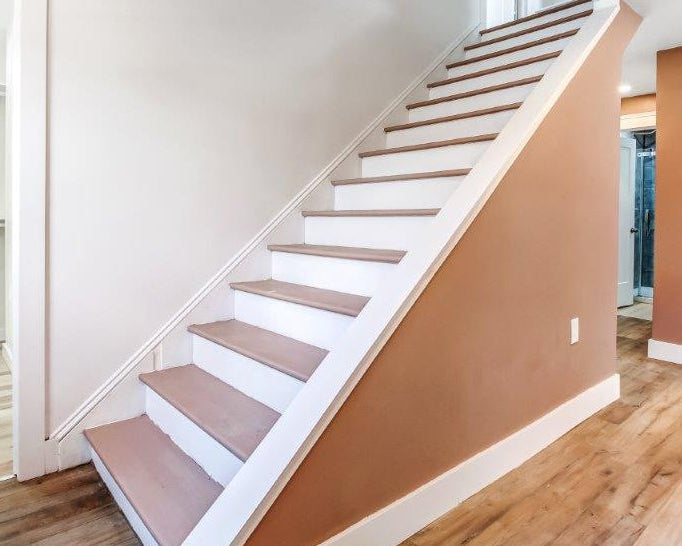 Interior staircase with wooden steps and white risers in residential home.