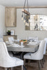 Dining room with a wooden table, chairs, and a chandelier.